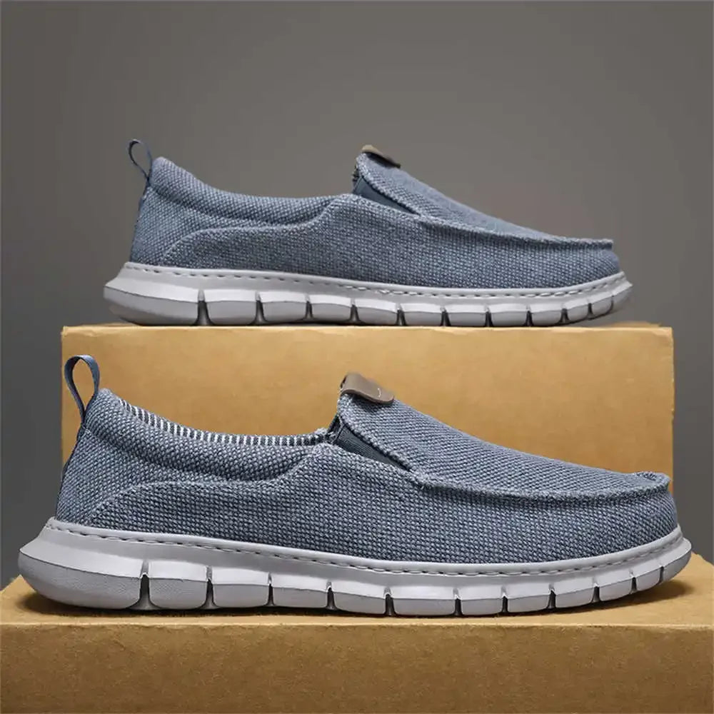 Zwei blaue Freizeitschuhe aus Stoff auf einem Karton, seitlich fotografiert. Bequeme, leichte Slipper mit weißer Sohle, ideal für Alltag und Freizeit.