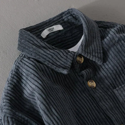 Graues Cordhemd mit Knopfleiste und Kragen, Detailansicht. Hochwertige Textur, modisches Design, ideal für Herbstmode.
