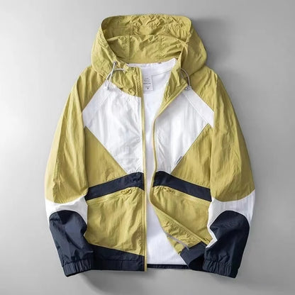 Gelbe und weiße Windjacke mit Kapuze, geometrischem Design und Reißverschluss. Modische Herrenjacke, ideal für Outdoor-Aktivitäten und Freizeitkleidung.
