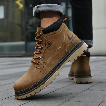 Braune Herren-Wanderstiefel mit robustem Profil, Schnürung und Logo, getragen auf grauem Pflaster. Outdoor-Schuhe, wasserdicht, rutschfest.