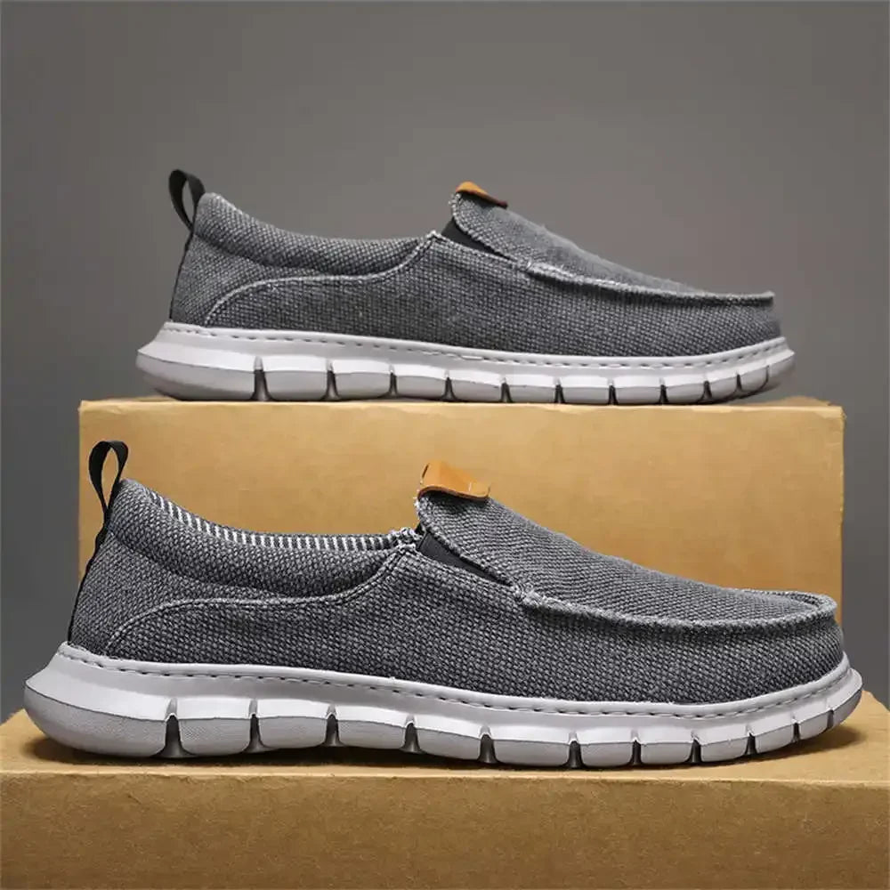 Graue Herren-Sneaker aus Stoff mit weißer Sohle, präsentiert auf einem Karton. Bequeme, modische Freizeitschuhe für Alltag und Sport.