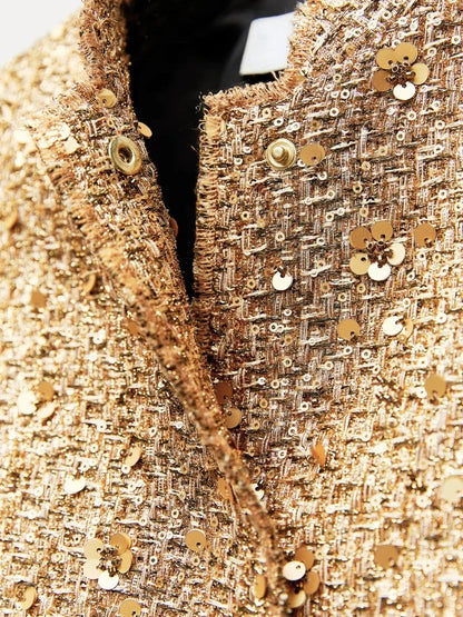Goldene Paillettenjacke aus Tweed mit Blumenmuster, Nahaufnahme. Luxusmode, glamouröse Damenbekleidung, elegantes Design.