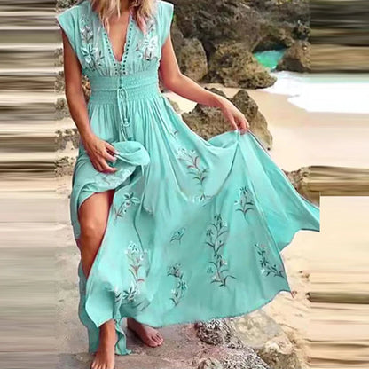 Frau in türkisfarbenem Sommerkleid mit Blumenstickerei am Strand, hält den Rock hoch. Perfekt für Strandmode, Sommerkleider, Urlaubsoutfits.