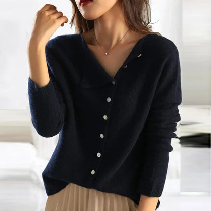 Dunkelblauer Damenpullover mit V-Ausschnitt und Knopfleiste, kombiniert mit beigem Rock. Modischer Herbst-Look, elegant und stilvoll.