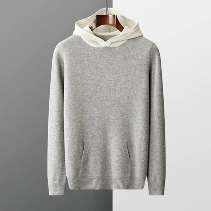 Grauer Kapuzenpullover aus Baumwolle auf Holzkleiderbügel, minimalistisch, modisch, bequem, ideal für Herbst und Winter, Herrenmode.
