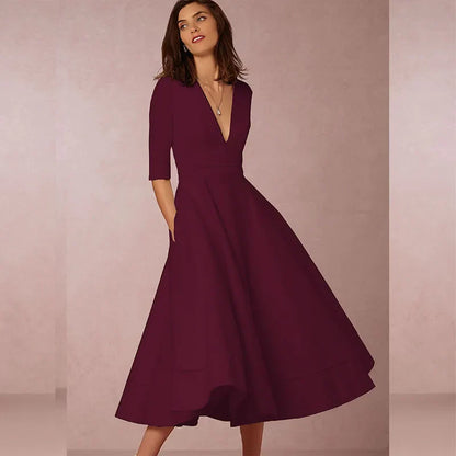 Frau in elegantem, weinrotem Kleid mit V-Ausschnitt und halblangen Ärmeln vor neutralem Hintergrund. Mode, Abendkleid, Damenbekleidung.