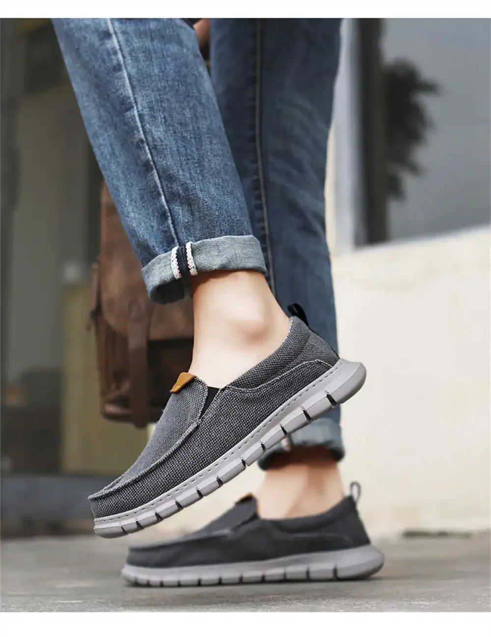 Graue Herren-Sneaker aus Stoff, kombiniert mit blauen Jeans. Bequeme, rutschfeste Freizeitschuhe für den Alltag. Ideal für stilvolle Freizeitoutfits.