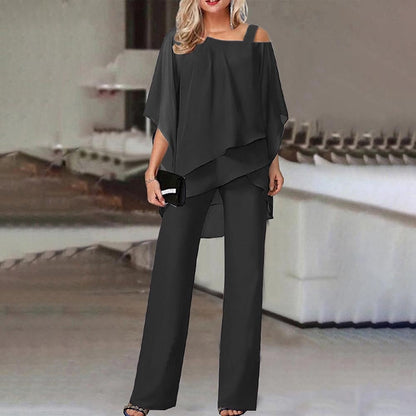 Elegante Frau in schwarzem, schulterfreiem Hosenanzug mit Clutch, stehend in modernem Innenraum. Modetrend, Damenbekleidung, Abendmode.