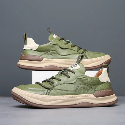 Grüne Ledersneaker mit beiger Sohle, modernem Design und Schnürung, auf grauem Hintergrund. Trendige Herrenschuhe, ideal für Freizeitmode.