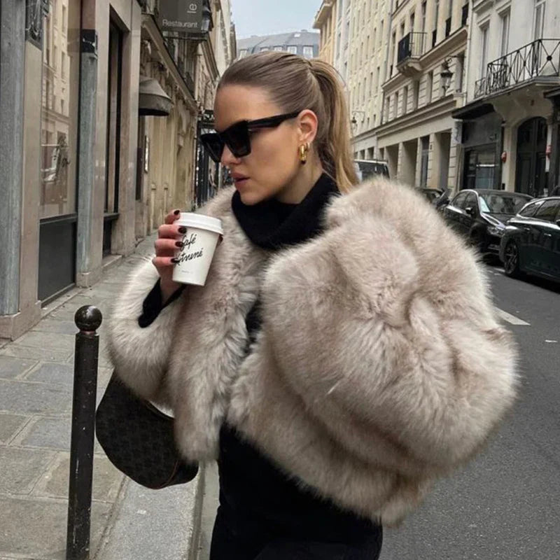Frau in eleganter Pelzjacke, Sonnenbrille und Pferdeschwanz trinkt Kaffee auf Pariser Straße. Mode, Luxus, Stadtleben.
