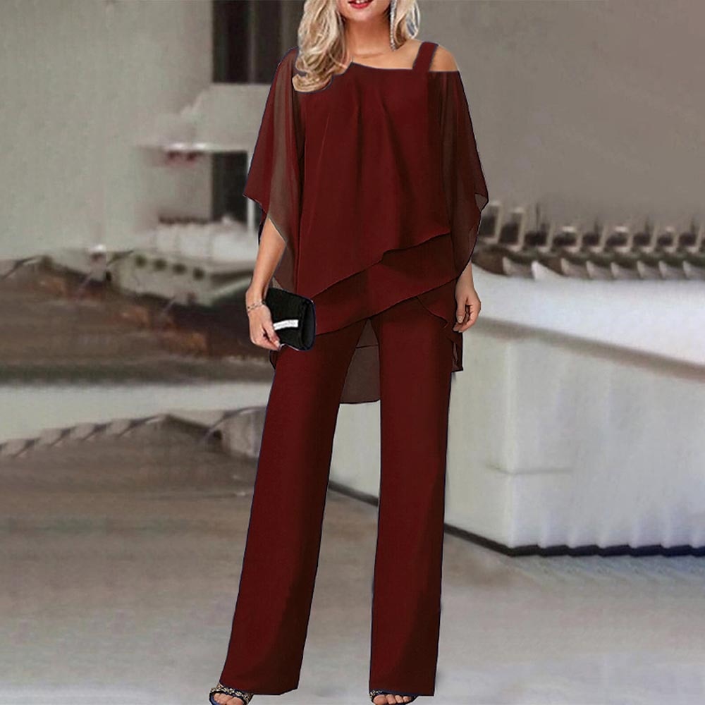 Frau in eleganter, weinroter Chiffon-Hose und asymmetrischer Bluse, Abendmode, moderne Damenbekleidung, stilvoll, schick, modisch.