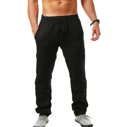 Mann in schwarzer Jogginghose und grauen Sneakers, sportlich, Fitnessmode, Freizeitkleidung, isoliert auf weißem Hintergrund.