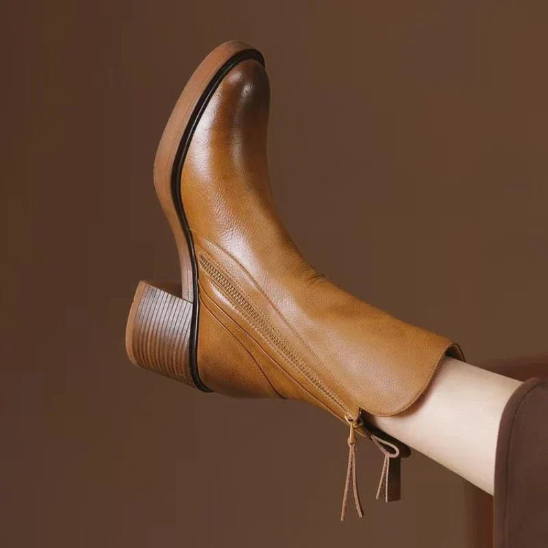 Brauner Lederstiefel mit Blockabsatz, seitlichem Reißverschluss und Quasten-Detail, stilvoll und modern, ideal für Herbstmode und Damenbekleidung.
