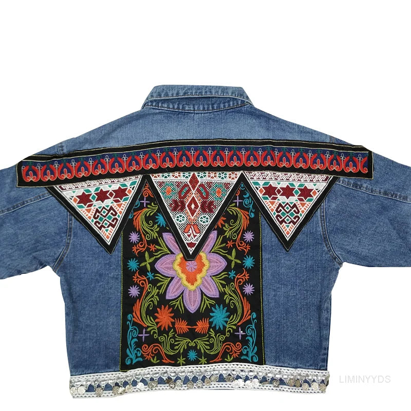 Bunte, bestickte Jeansjacke mit floralen Mustern und geometrischen Designs auf der Rückseite, traditioneller Stil, auffällige Mode.