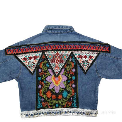 Bunte, bestickte Jeansjacke mit floralen Mustern und geometrischen Designs auf der Rückseite, traditioneller Stil, auffällige Mode.