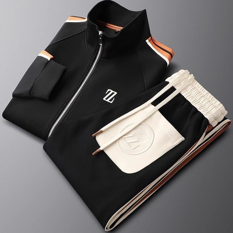 Schwarzer Designer-Trainingsanzug mit weißem Logo, Reißverschlussjacke und elastischer Hose, modisch und sportlich, auf grauem Hintergrund.