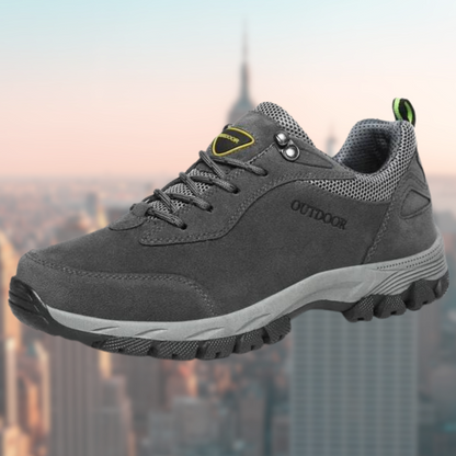 Grauer Outdoor-Wanderschuh mit robustem Profil, ideal für Trekking und Abenteuer. Bequeme Passform, atmungsaktives Material, langlebige Sohle.