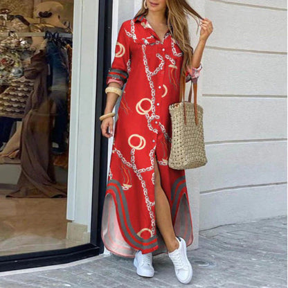 Frau in rotem Maxikleid mit Kettenmuster, trägt Strohtasche und weiße Sneaker, steht vor Schaufenster. Sommermode, lässiger Stil, Stadtbummel.