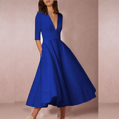 Frau in elegantem, blauem Kleid mit V-Ausschnitt und halblangen Ärmeln, knielang, modisch, Abendmode, stilvoll, zeitloses Design.
