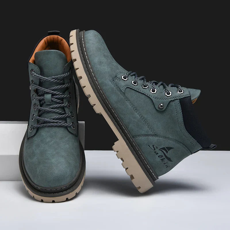Graue Herren-Wanderschuhe mit robusten Sohlen, Schnürsenkeln und seitlichem Logo. Ideal für Outdoor-Aktivitäten und Trekking.
