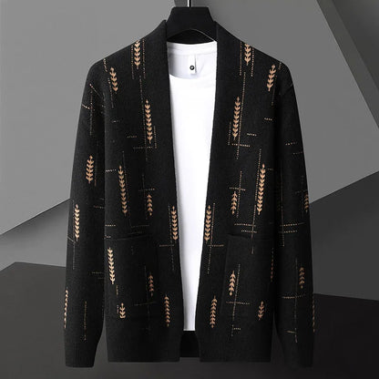 Schwarzer Cardigan mit braunem Blattmuster, hängend auf einem Kleiderbügel, vor grauem Hintergrund. Modischer Herrenstrickjacke, elegant und stilvoll.