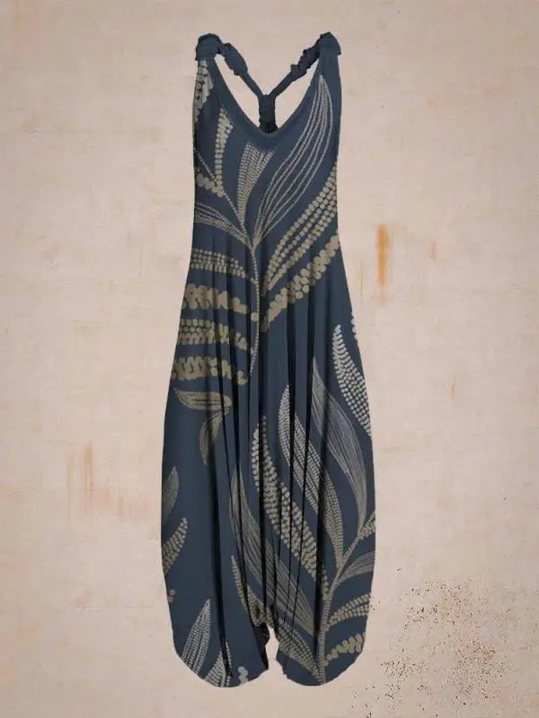 Dunkelblauer Jumpsuit mit beige Blattmuster, ärmellos und locker geschnitten, vor neutralem Hintergrund. Modetrend, Damenbekleidung, Sommeroutfit.