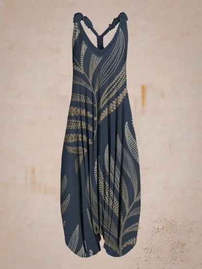 Dunkelblauer Jumpsuit mit beige Blattmuster, ärmellos und locker geschnitten, vor neutralem Hintergrund. Modetrend, Damenbekleidung, Sommeroutfit.