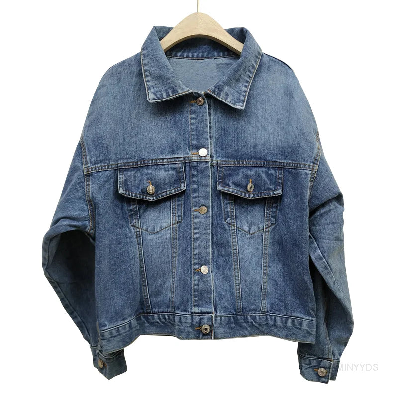 Blaue Jeansjacke auf Holzkleiderbügel, klassisches Design mit Knopfleiste und Brusttaschen, lässige Damenmode, zeitloser Denim-Look.
