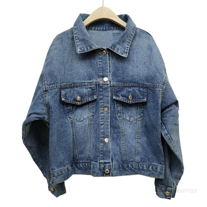 Blaue Jeansjacke auf Holzkleiderbügel, klassisches Design mit Knopfleiste und Brusttaschen, lässige Damenmode, zeitloser Denim-Look.