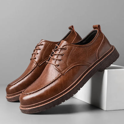 Braune Herrenschuhe aus Leder mit Schnürung, rutschfeste Sohle, elegantes Design, ideal für Business und Freizeit, auf grauem Hintergrund.