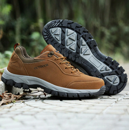 Braune Outdoor-Wanderschuhe mit rutschfester Sohle auf gepflastertem Weg im Wald. Ideal für Trekking und Abenteuer. Robuste, langlebige Materialien.