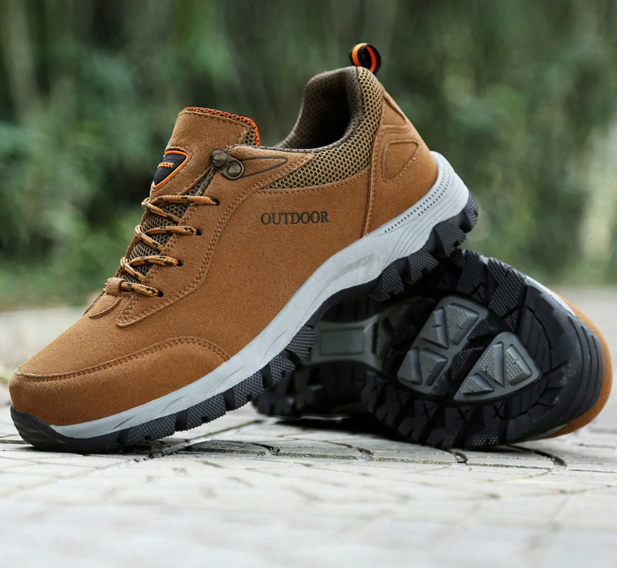 Braune Outdoor-Wanderschuhe mit rutschfester Sohle auf Steinboden, ideal für Trekking und Hiking. Robustes Design, atmungsaktives Material.