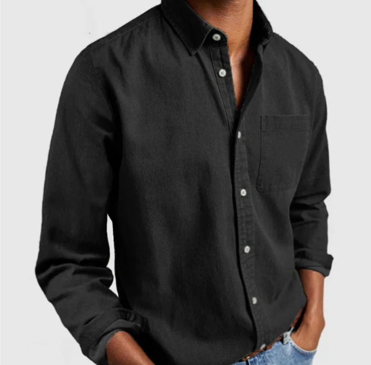 Mann in schwarzem Hemd mit Knopfleiste und Brusttasche, lässig in Jeans. Mode, Herrenbekleidung, Freizeitlook, stilvolles Outfit.