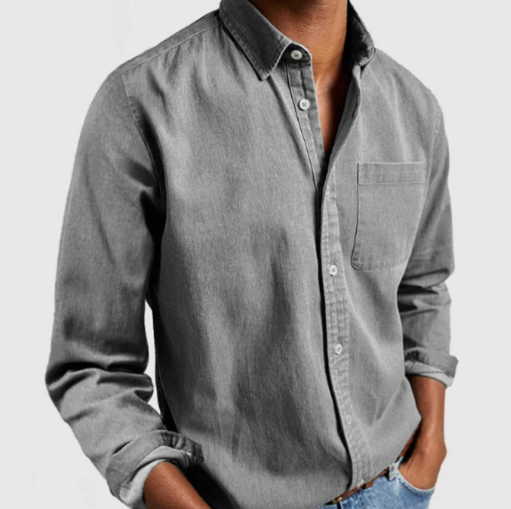 Graues Herrenhemd aus Baumwolle, langärmlig, mit Brusttasche und Knopfleiste, lässig getragen zu blauen Jeans. Ideal für Freizeitmode.