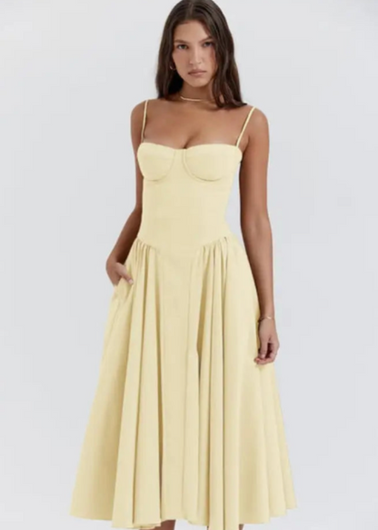 Frau in elegantem, gelbem Sommerkleid mit Spaghettiträgern und ausgestelltem Rock. Mode, Damenbekleidung, stilvolles Design, Sommeroutfit.