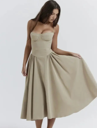 Frau in beige, ärmellosem Kleid mit ausgestelltem Rock, elegantes Design, Modefotografie, minimalistischer Hintergrund.