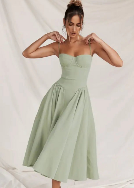 Frau in elegantem, mintgrünem Kleid mit Spaghettiträgern und ausgestelltem Rock vor weißem Hintergrund. Mode, Damenkleidung, Sommerkleid.