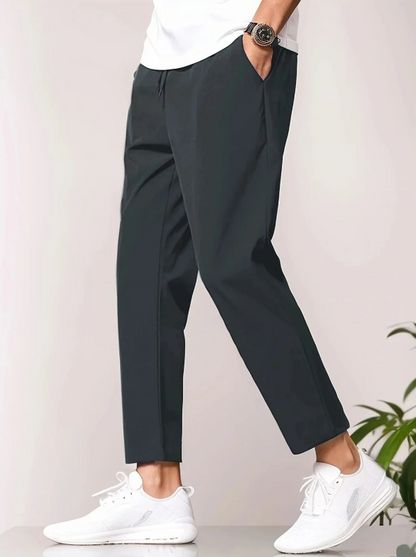 Herrenmode: Schwarze Chinohose, kombiniert mit weißen Sneakers und weißem T-Shirt. Stilvolle Freizeitkleidung für Männer.