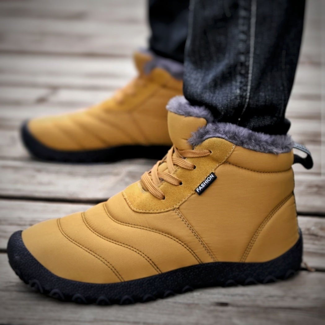 Gelbe Winterstiefel mit Fellfutter, getragen auf Holzdeck. Modische, warme Schuhe für Herren, ideal für kalte Jahreszeiten. Outdoor-Wintermode.