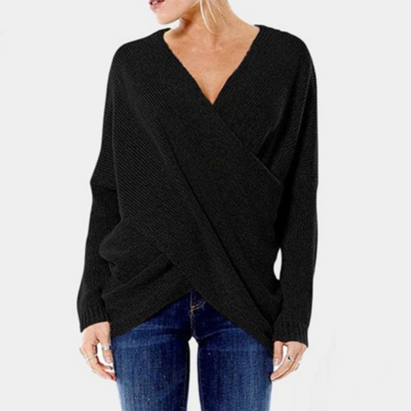 Frau trägt schwarzen, überkreuzten Strickpullover mit V-Ausschnitt und blauen Jeans. Modischer Damenpullover, lässiger Herbstlook.