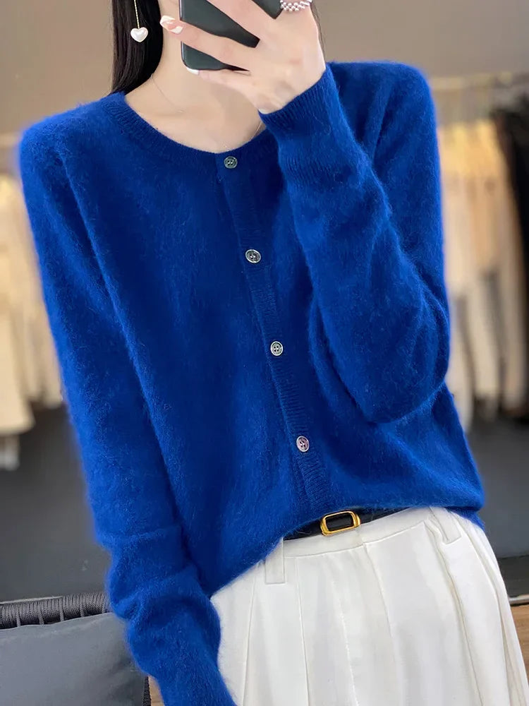Frau in blauem Strickcardigan mit Knöpfen, weißer Hose und schwarzem Gürtel. Mode, Damenbekleidung, eleganter Look, Herbstmode.
