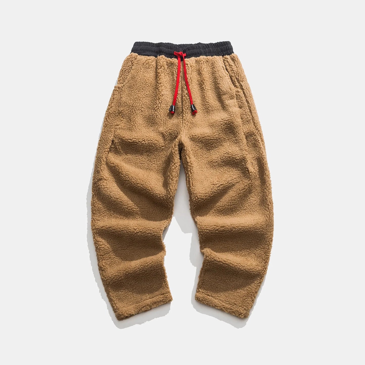Braune Fleece-Jogginghose mit elastischem Bund und rotem Kordelzug auf weißem Hintergrund. Bequeme, warme Herrenmode für Herbst und Winter.