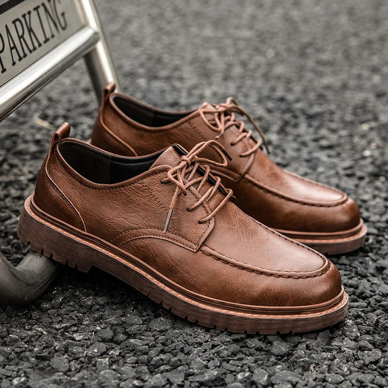 Braune Herrenschuhe aus Leder mit Schnürung auf Asphalt. Elegante, robuste Freizeitschuhe, ideal für stilvolle Alltagsoutfits.