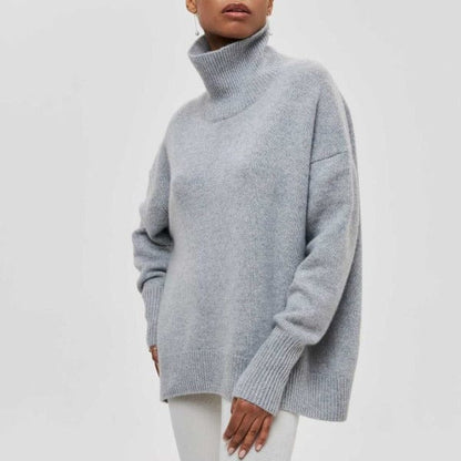 Frau trägt grauen Rollkragenpullover, gemütlich und modisch, aus weichem Strickmaterial. Perfekt für Herbst- und Wintermode.