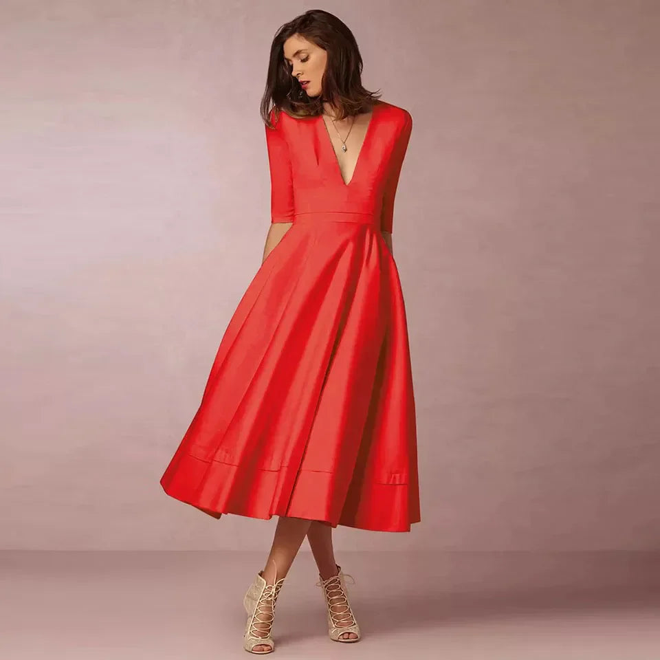 Frau in elegantem, rotem Kleid mit V-Ausschnitt und halblangen Ärmeln, posiert vor neutralem Hintergrund. Mode, Damenbekleidung, Abendkleid.