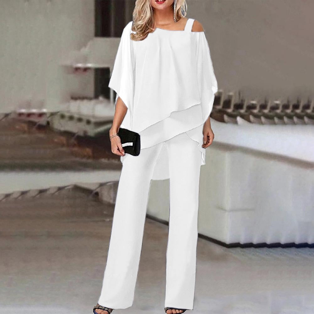 Frau in eleganter weißer Off-Shoulder-Bluse und Hose, hält schwarze Clutch. Stilvolle Abendmode, modernes Design, schickes Outfit für besondere Anlässe.