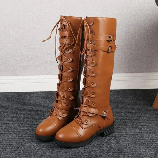 Braune Damenstiefel mit Schnürung und Schnallen, kniehoch, auf grauem Teppich. Modische Lederstiefel für Herbst und Winter.