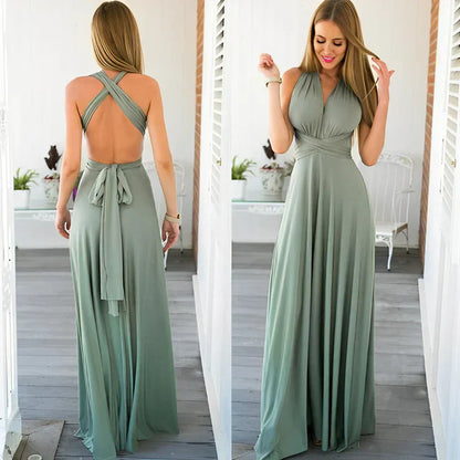 Frau in langem, grünem Abendkleid mit Rückenausschnitt und Wickeldesign, steht auf Veranda. Elegantes Maxikleid, Sommermode, Damenbekleidung.