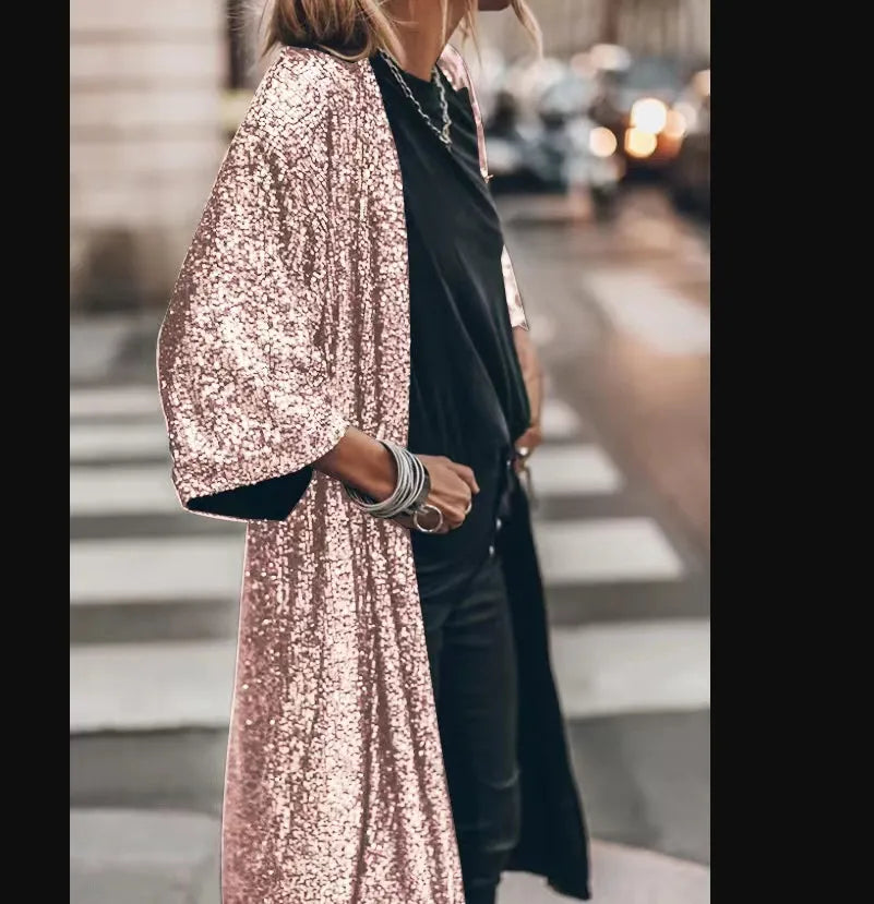 Frau in schimmerndem, roségoldenem Paillettenmantel auf einer Stadtstraße. Modetrend, glamouröser Look, urbaner Stil, Abendmode.