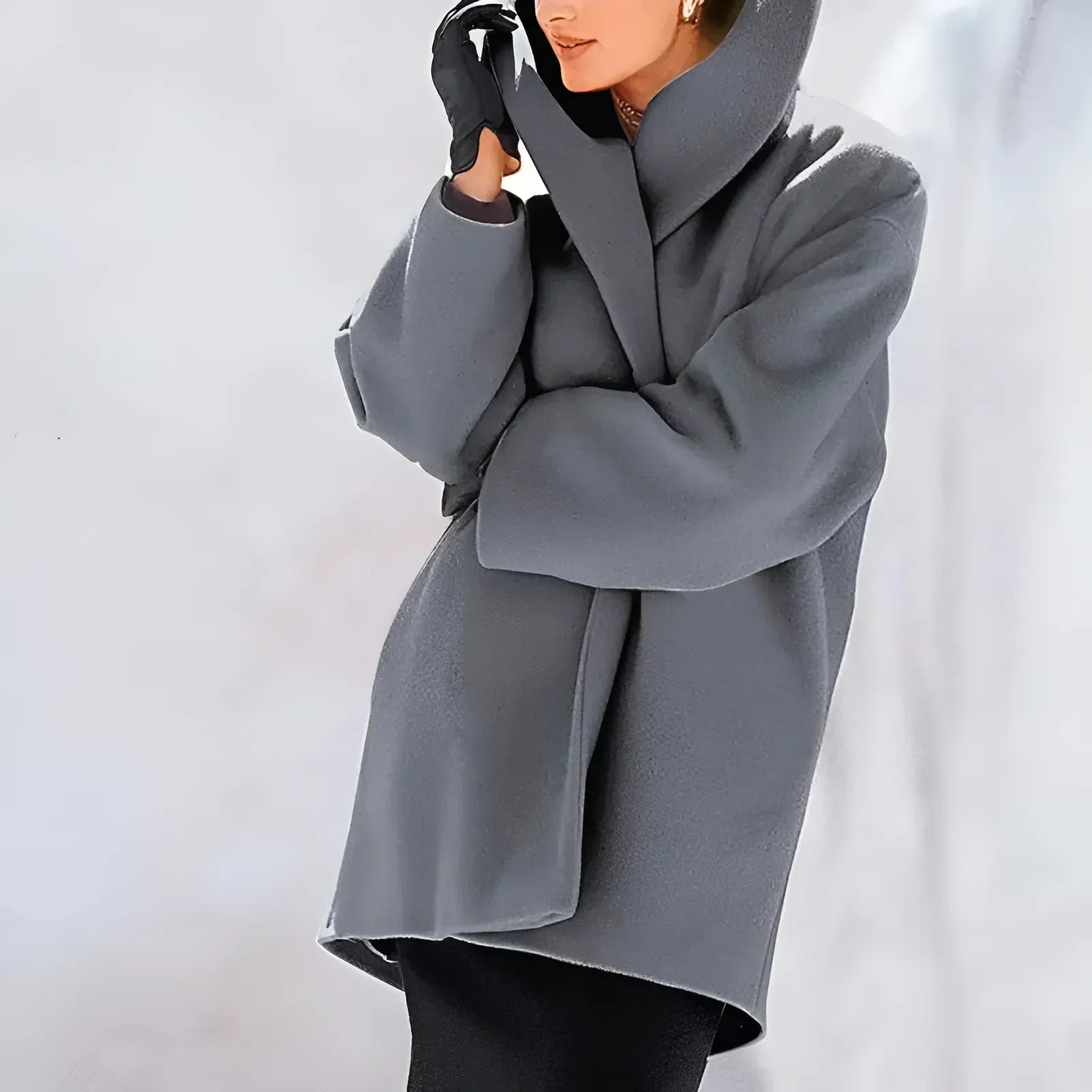 Grauer Wintermantel für Damen, elegant und modern, mit Kapuze und Handschuhen. Perfekt für stilvolle Wintermode und kalte Tage.